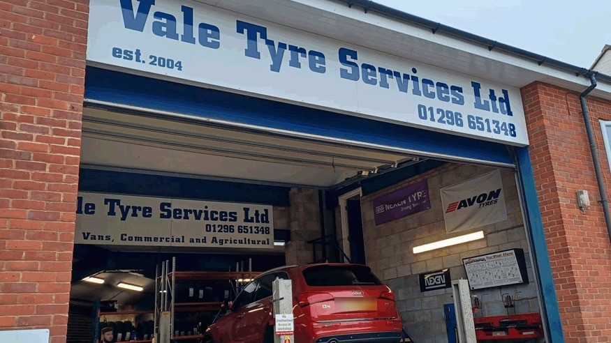 Red Audi Q5 inside the bay under the Vale Tyre Services Ltd est. 2004 sign