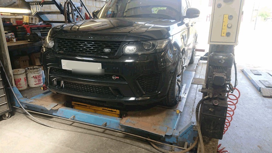 Black Range Rover Sport on the alignment ramp