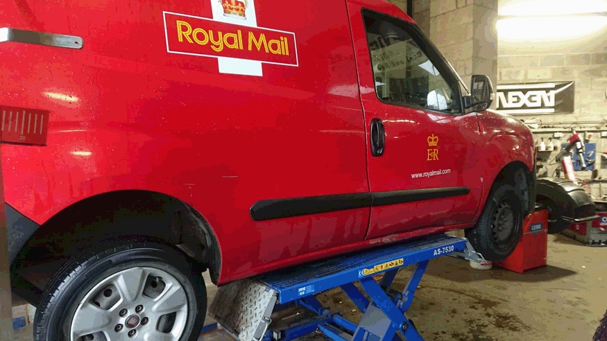 Red Royal Mail van up on the lift in the workshop