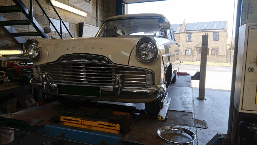Front of a cream Ford Zodiac in the workshop bay