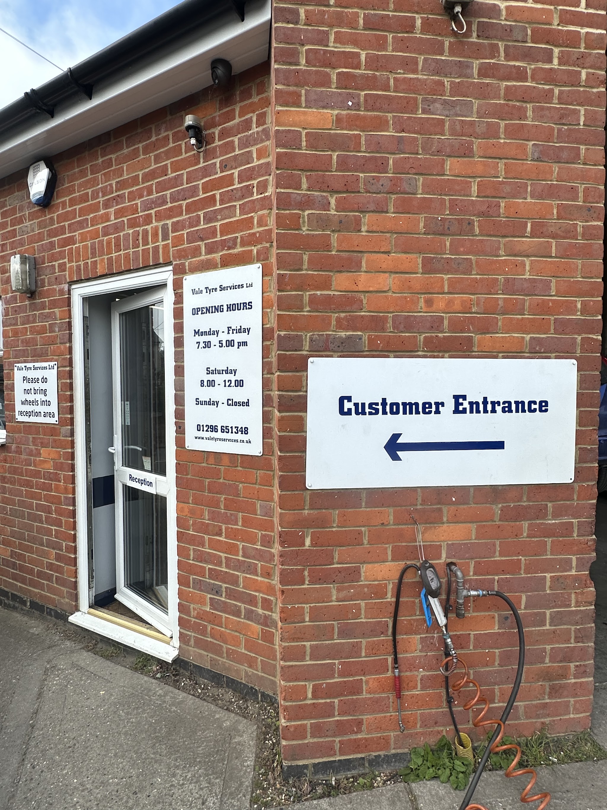 The customer entrance door with the opening hours notice beside it